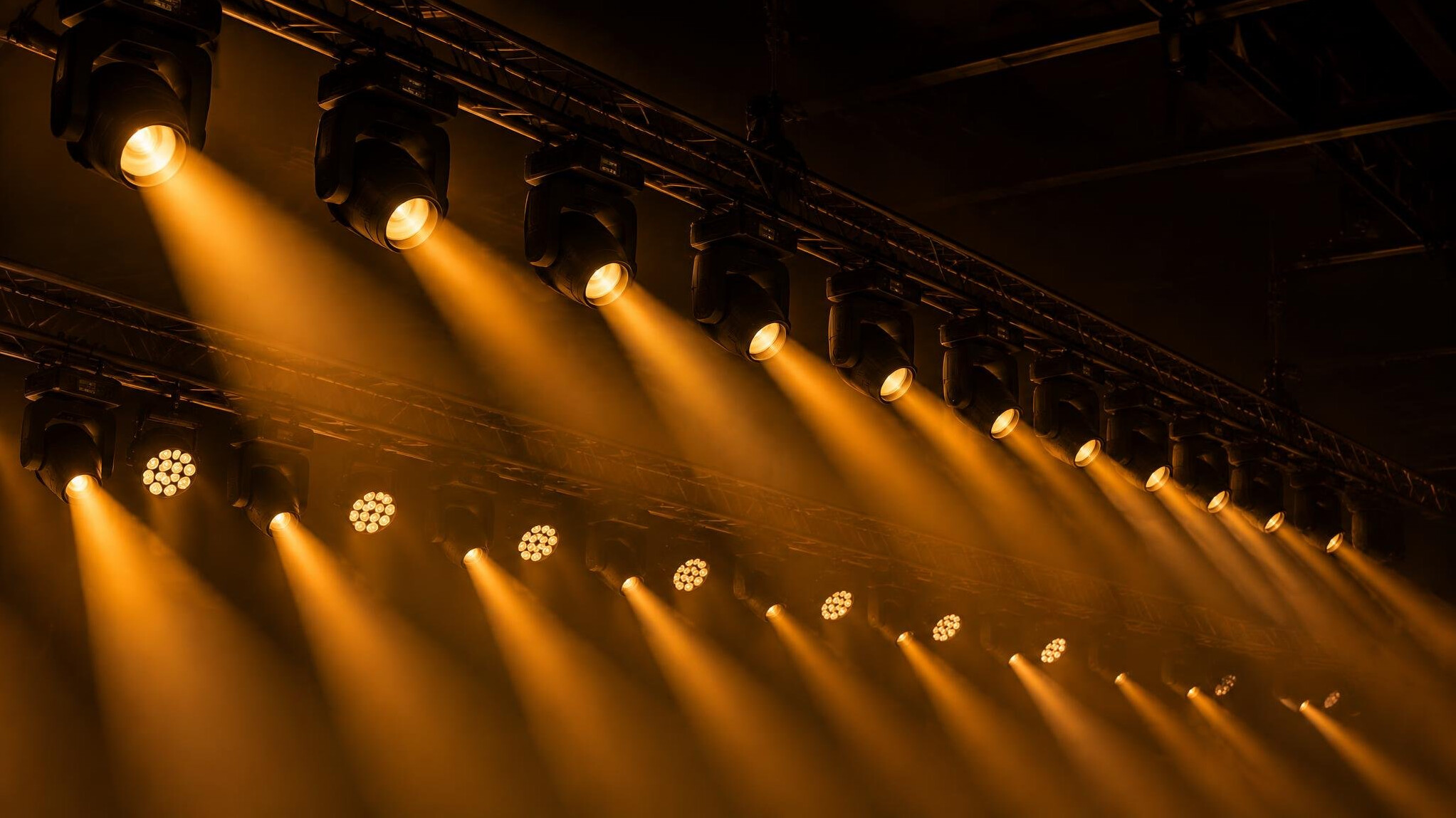 Stage lights beams over a dark venue